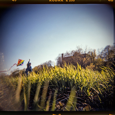 girl with kite, old buildings, dreamy photo, Kodak Ektachrome, Holga